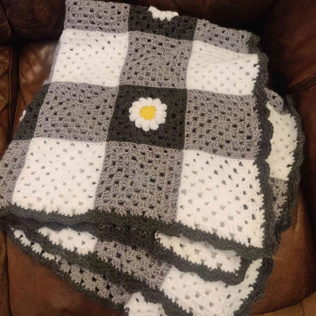 Gray Granny square with white and yellow daisy crochet blanket 