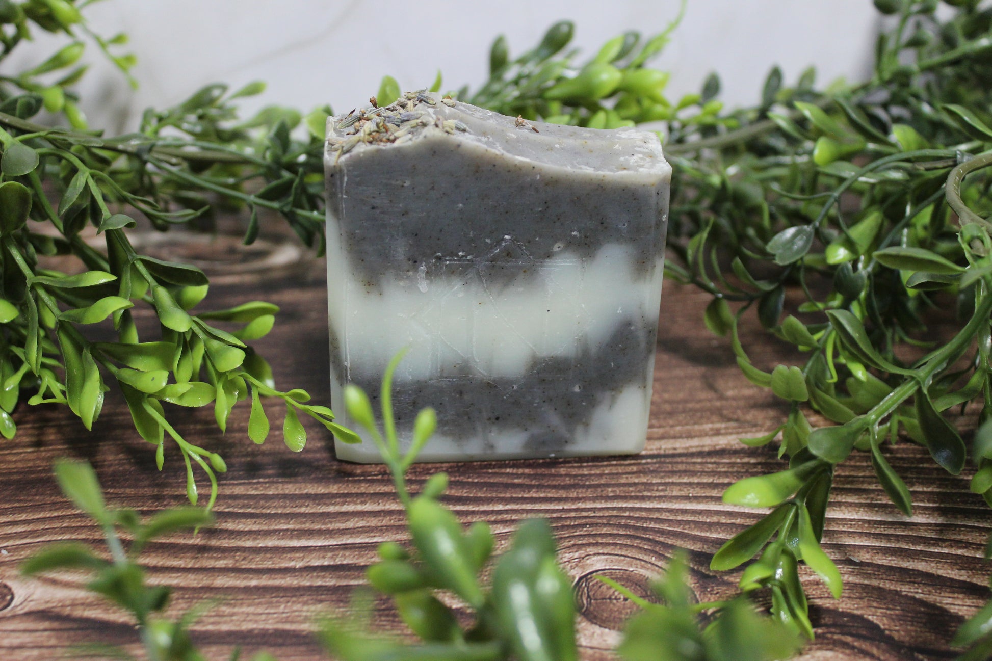 Striped soap bar with greenery on a wooden surface