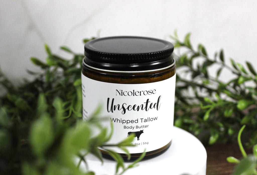 Jar of Nicolerose Unscented Whipped Tallow Body Butter on a white surface with greenery in the background