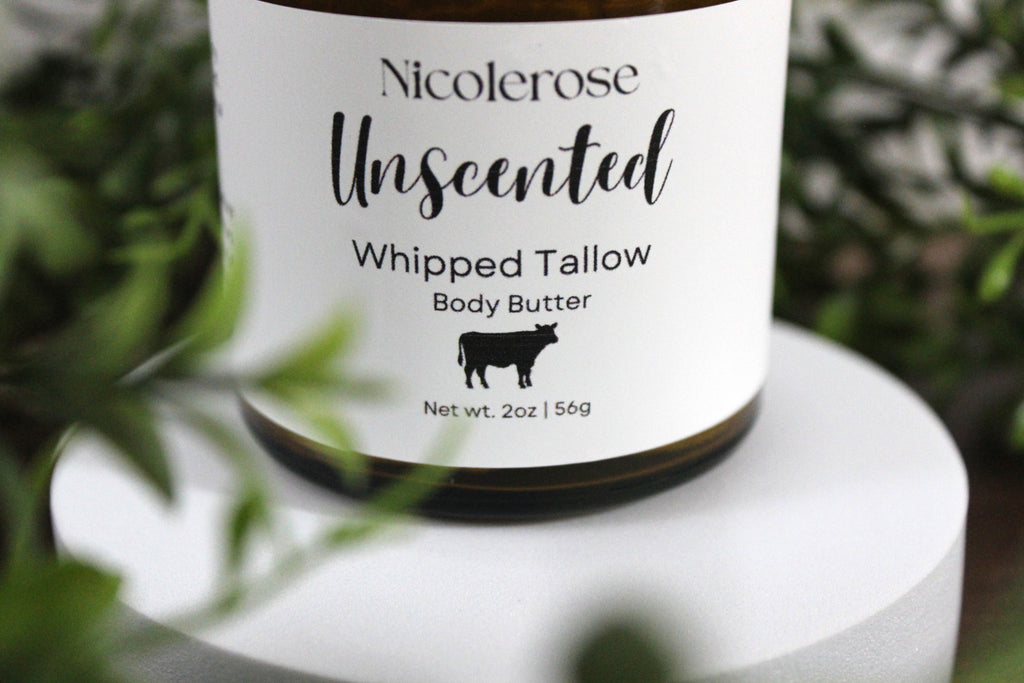 Nicolerose Unscented Whipped Tallow Body Butter jar with label on a white surface with greenery in the background