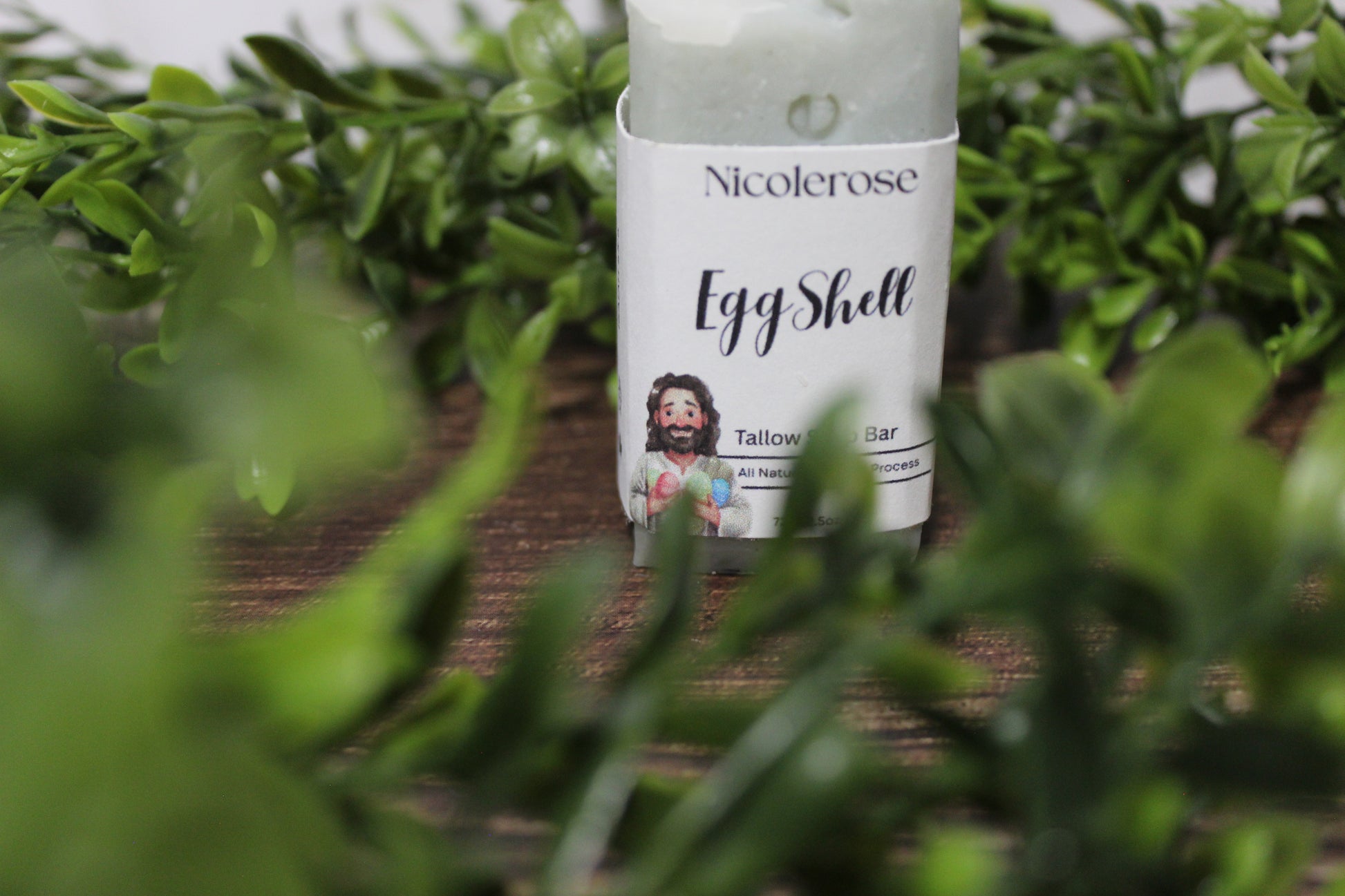 Nicolerosse Egg Shell product on a wooden surface with greenery in the background